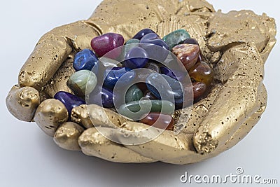 Assorted gems and crystals in Golden hands. Stock Photo