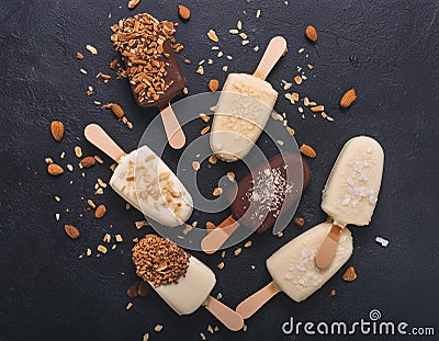 Assorted gourmet ice cream popsicles with toppings on black background Stock Photo