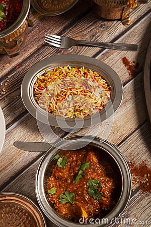 Assorted Indian dishes of rice and curry on wooden background. Top view. Vertical picture Stock Photo