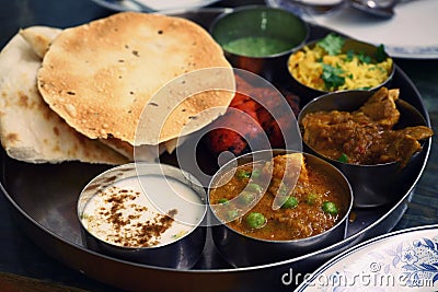 Assorted Indian food set in tray, tanduri chicken, naan bread, yoghurt, traditional curry, roti Stock Photo