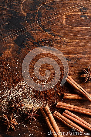 Assorted natural cinnamon, cane brown sugar, ground coffee, anise stars baking ingredients on a rustic brown Stock Photo