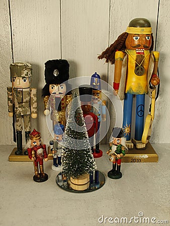 Assorted Nutcrackers, around frosted Christmas tree Stock Photo