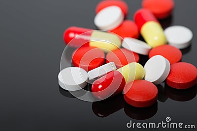 Assorted pharmaceutical medicine pills, tablets and capsules over black background Stock Photo