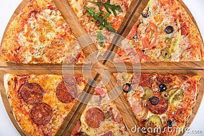 Assorted pizza with different fillings on a wooden platter Stock Photo