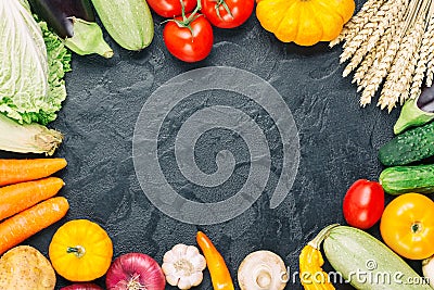 Assorted raw organic fresh vegetables on black stone background. Fresh garden vegetarian food. Autumn seasonal frame of farmer Stock Photo