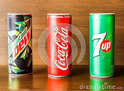 Assorted soft drink cans with coke, 7up and dew isolated on wooden background side view of indian spices and pakistani food Editorial Stock Photo