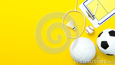 Assorted sports equipment including a soccer ball, volleyball, baseball, badminton racket on a yeallow background Stock Photo