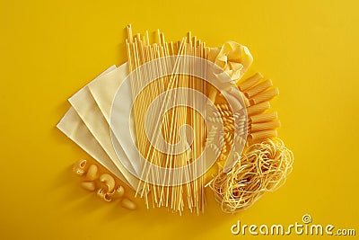 Assorted types of pasta on yellow background. Stock Photo