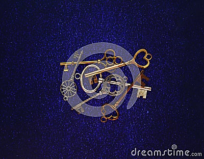 Assorted vintage gold and silver keys on blue background Stock Photo