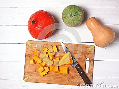 Assortment of autumn pumpkins isolated on white background. Pieces of sliced pumpkin on the Board. Stock Photo