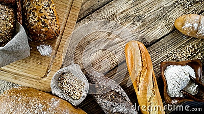 Assortment of baked bread and bread rolls on wooden table background Stock Photo