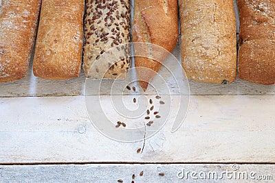 Assortment of baked bread on a white wood table. Stock Photo