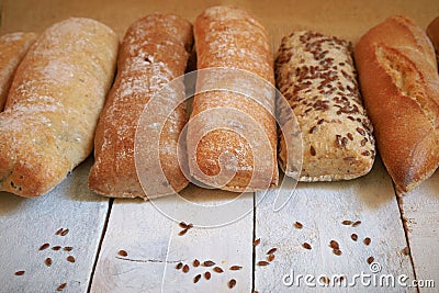 Assortment of baked bread on a white wood table. Stock Photo