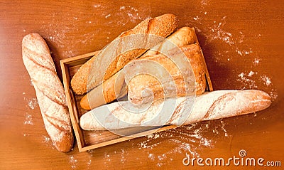 Assortment of baked wheat bread on wooden background. Stock Photo