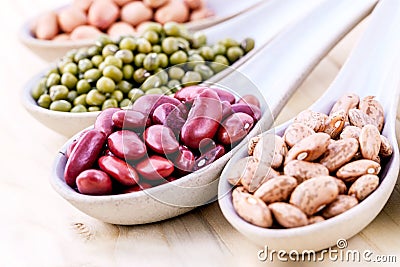 Assortment of beans and lentils in wooden spoon isolate on white Stock Photo