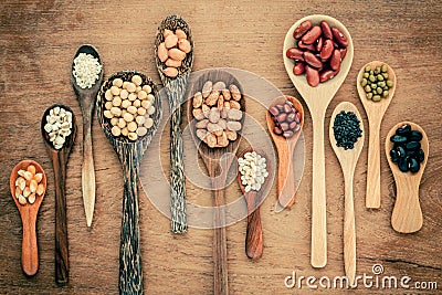 Assortment of beans and lentils in wooden spoon on teak wood background. mung bean, groundnut, soybean, red kidney bean , black b Stock Photo