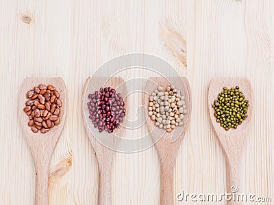 Assortment of beans and lentils in wooden spoon on wooden background. soybean, mung bean , red bean and brown pinto beans . Stock Photo