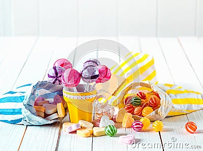 Assortment of candies in bags and cup over a table Stock Photo