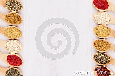 Assortment colorful powdered spices in bamboo spoons as decorative border. Stock Photo