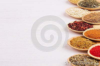 Assortment colorful powdered spices in bamboo spoons, copy space, closeup. Stock Photo