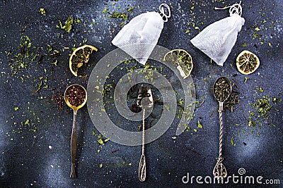 Assortment of dry tea on vintage silverware spoons and teabags, black, flower, green, and mint tea Stock Photo