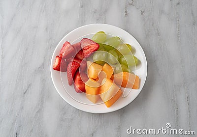 Assortment of fresh fruit on a white plate Stock Photo