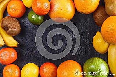 Assortment of Fresh tropical fruits orange, tangerine, banana, grapefruit, lemon, lime, kiwi on dark background Stock Photo