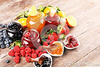 Assortment of jams, seasonal berries jelly, mint and fruits and tangerine Stock Photo