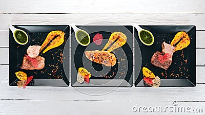 Assortment of meat dishes. Chicken meat, veal and pork with sauce. On a wooden background Stock Photo