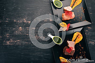 Assortment of meat dishes. Chicken meat, veal and pork with sauce. On a wooden background Stock Photo