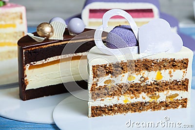 Assortment of pieces of cake on messy table, copy space. Several slices of delicious desserts Stock Photo