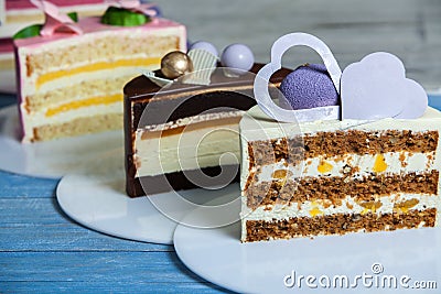 Assortment of pieces of cake on messy table, copy space. Several slices of delicious desserts Variety of tasty cakes Stock Photo