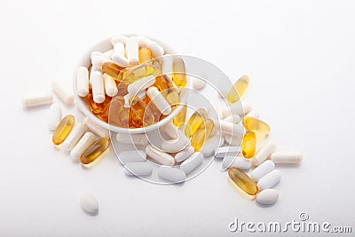 Assortment scattered pharmaceutical medicine vitamins, pills, drugs in bowl on gray background. White food dietary Stock Photo