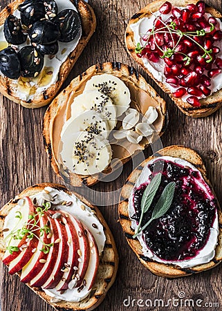 Assortment sweet sandwiches with cream cheese and apple, pomegranate, jam, grapes, peanut butter, banana, flax seed, chia, nuts on Stock Photo