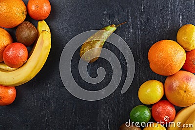 Assortment of tropical fruits orange, tangerine, banana, lemon, lime, kiwi on dark background. Fresh fruit set Stock Photo