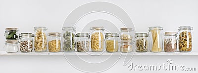 Assortment of uncooked groceries in glass jars arranged on shelf Stock Photo