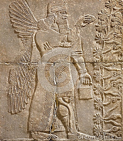 Assyrian wall relief of a winged genius with cuneiform Stock Photo