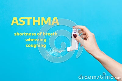 Asthma. A female`s hand presses the pump of the inhaler, spraying the medicine. Side view. Blue background with text Stock Photo