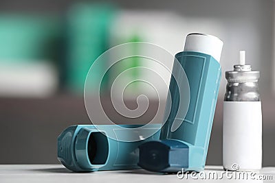 Asthma inhalers on table against blurred background Stock Photo