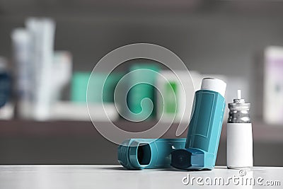 Asthma inhalers on table against blurred background. Stock Photo