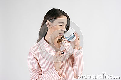 Asthmatic woman using an asthma inhaler during asthma attacks Stock Photo