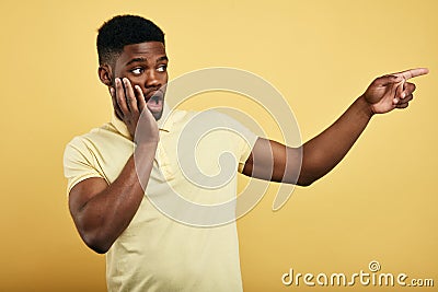 Astonished emotional young dark-skinned man dressed in stylish T-shirt Stock Photo