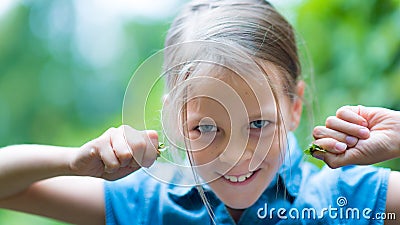 Astonished happy girl in blue shirt having fun in the park Stock Photo