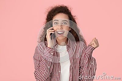 Astonished happy millennial lady talking on cellphone, listening amazing news. Stock Photo