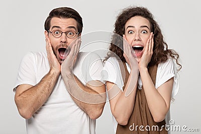 Astonished millennial guy and woman winners amazed by unbelievable news. Stock Photo