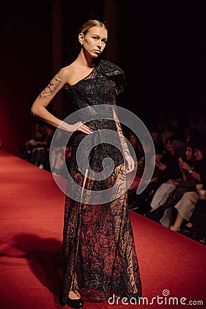 ASTRAKHAN RUSSIA - NOVEMBER 01, 2019. Caspian Fashion Week.A woman model walks the red runway.Fashion show,catwalk event Editorial Stock Photo