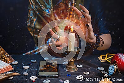 Astrology and online divination. A fortune teller does online fortune telling on photos from a smartphone. There are magic items Stock Photo