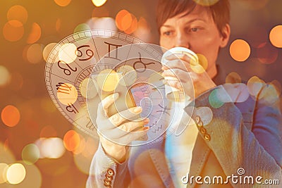 Astrology smartphone app, woman drinking coffee and reading horoscope and astrological predictions Stock Photo