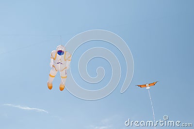 An astronaut and a little dragon kite at the kite festival at the storage sea geeste germany Editorial Stock Photo