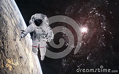 Astronaut in orbit of planet in deep space. Red spiral galaxy Stock Photo